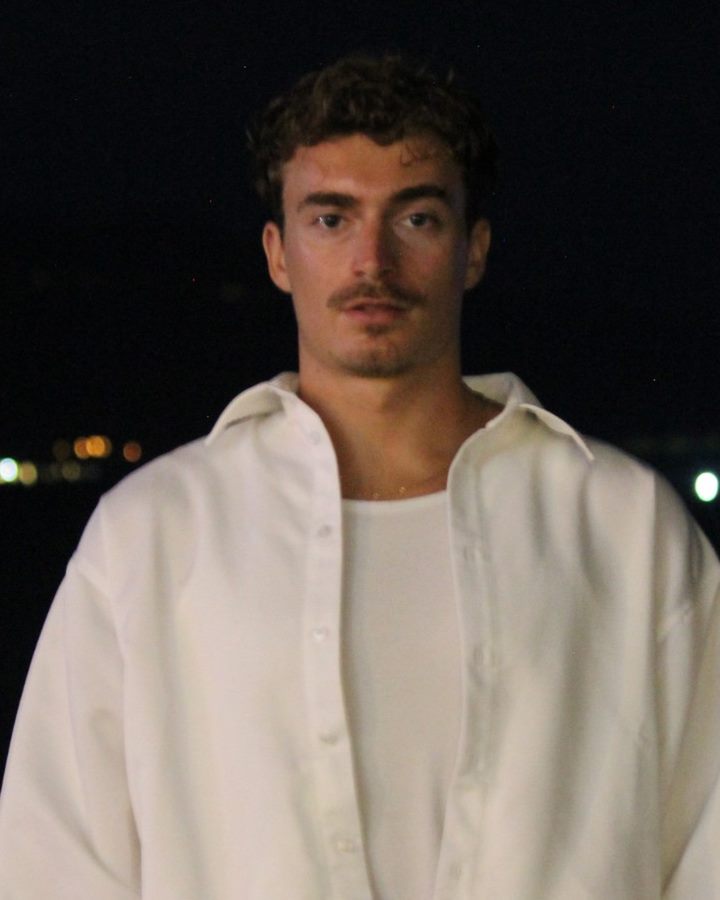 Dorian, designer de HOMWEB, photographié de nuit au flash, chemise blanche.